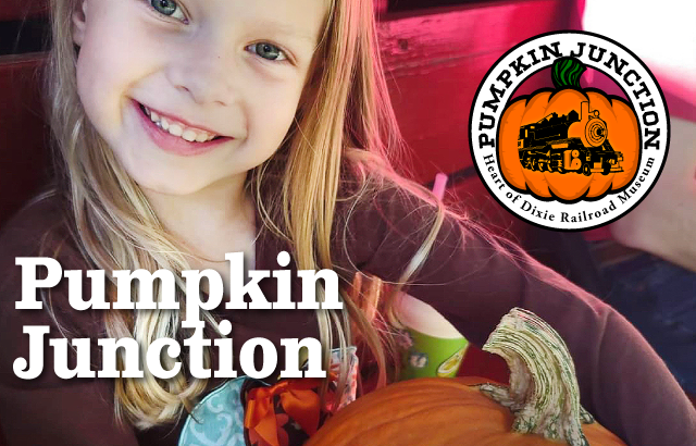 child wearing sweater holding pumpkin